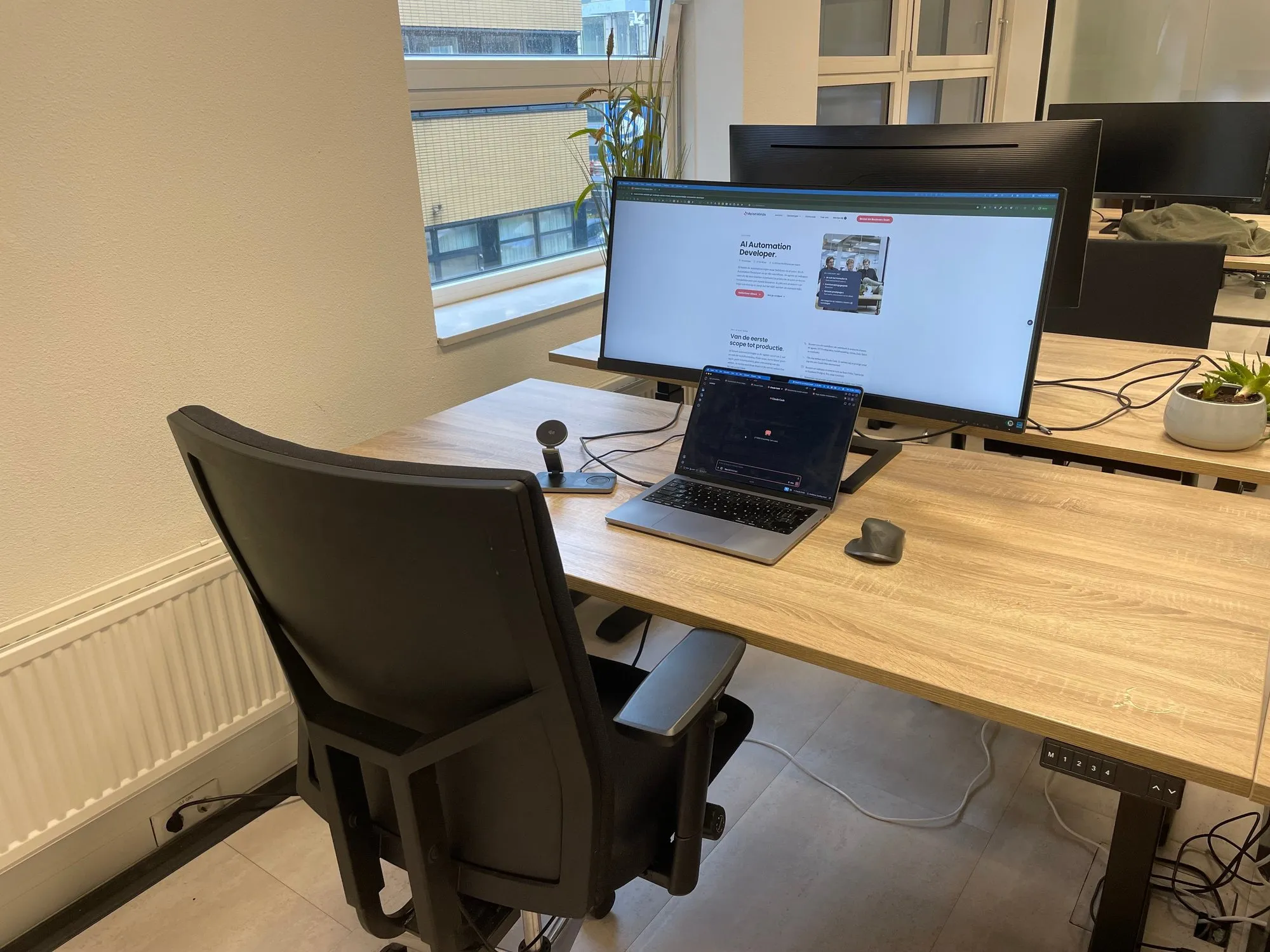 Een bureau op ons kantoor aan de Wenckebachweg, met laptop en breed scherm